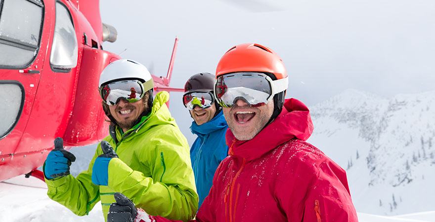 3 Männer vor einem Hubschrauber im Schnee