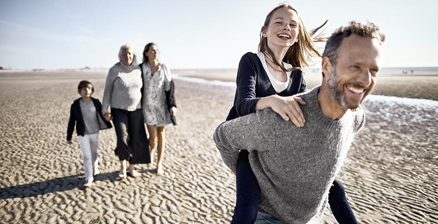 Familie beim Spaziergang am Wattenmeer Mädchen beim Vater auf dem Rücken