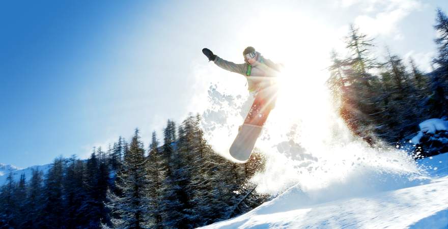 Ein Snowboarder bei waghalsigem Sprung